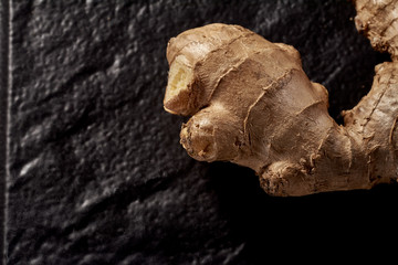 Ginger root on a black background. top view. volume ripe product. macro photo. Against viruses and diseases.