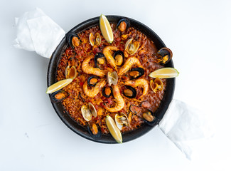 Fish and seafood paella on a white background