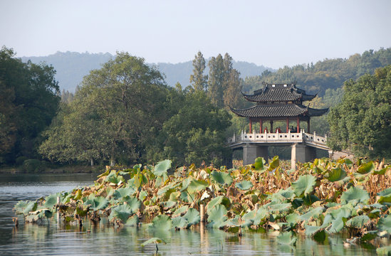 West Lake (Xi Hu) in Hangzhou, Zhejiang Province, China. Yudai bridge on West Lake, one of the famous symbols of Hangzhou city. West Lake is a major UNESCO tourist attraction in Hangzhou, China.