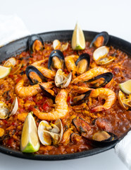 Fish and seafood paella on a white background