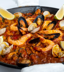 Fish and seafood paella on a white background