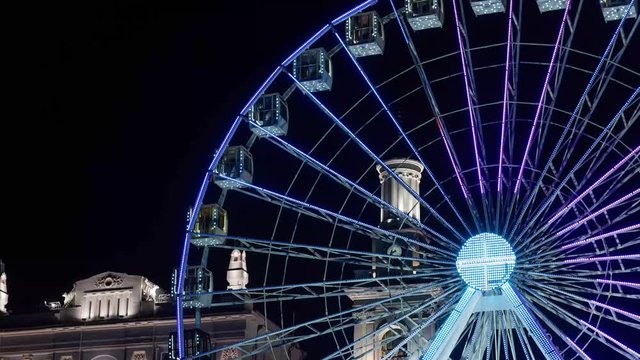 Timelapse illuminated ferris wheel in the night city.
