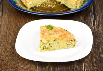 Slice of Turkish berek dish with cheese. Turkish national cuisine. Wood background.