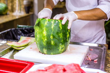 Chef cutting a delicious sweet watermelon