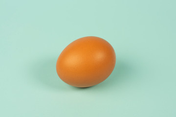 Fresh chicken egg on turquoise background