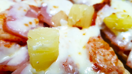 A piece of Hawaiian pizza close-up