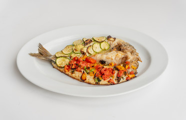 Baked fish with vegetables, zucchini and tomatoes