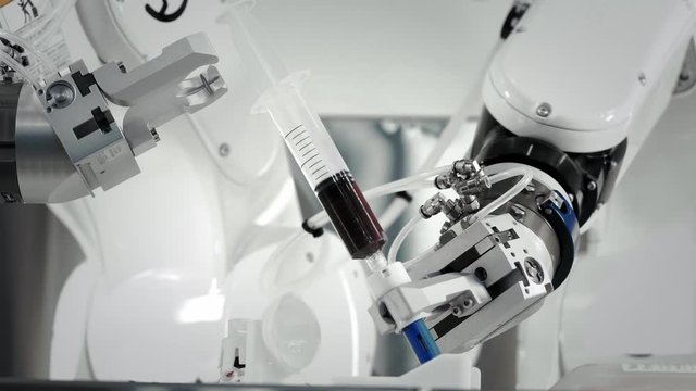 The innovative arms of a robotic arm make an injection of chemotherapy for a cancer patient. New technologies in medicine. Two manipulators draw medicine into a syringe. Hazardous substance injected