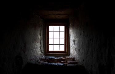 Fototapeta na wymiar Old castle window in a dark corner