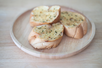 Wooden plate with delicious homemade garlic bread