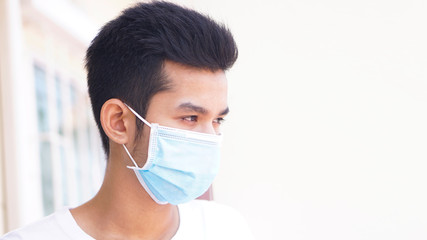 Young man praying and worship to GOD for stop spirituality and Surrender concept. Cover the mask to protect the germ or virus from the air. 2020-Corona virus from China.