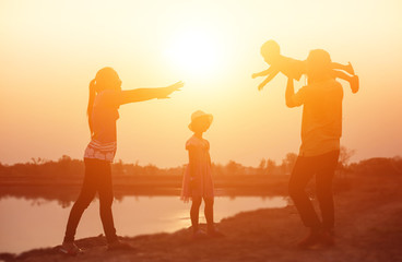 Fototapeta na wymiar silhouette of a happy family and happy time sunset