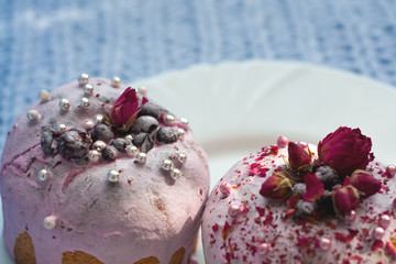 Cake with flowers, beads and nuts. Blue knitted plaid. Cozy Easter, spring still life scene. The concept of the Easter holidays and decor. 
