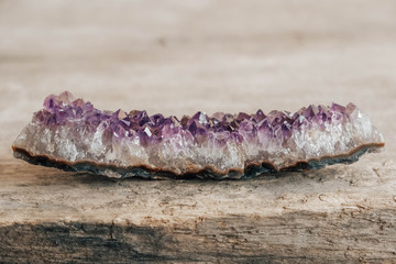 Violet amethyst crystal on wooden background. Copy, empty space for text
