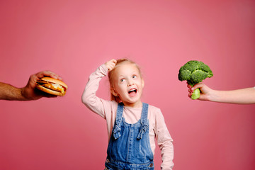 Hungry girl is hard to choose a burger or broccoli. Unheathy vs healthy food. Concept of choice.