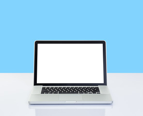 Laptop computer on desk with isolated screen for mockup on blue background. business and technology concept