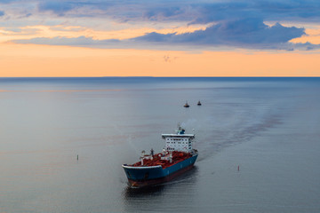 Naklejka premium Tanker at sea, aerial view. Large blue and white ship in the bay at sunset.