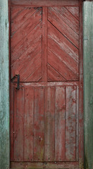 Red wooden door to the staircase. Old peeling paint