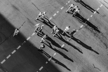 Street photo of people crossing the road at a pedestrian crossing. View from above