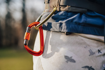 Climbing carabiner cliped or connected to a climbing harness. Climber wearing a harness with biner...