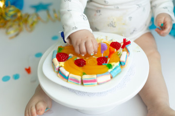 little baby hand holding a carrot on a stick. first cake. the first day of birth. cake smash