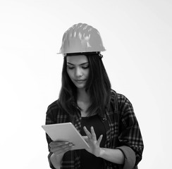 The young woman engineer wearing safety helmet,using tablet for searching data,black and white tone
