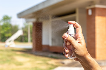 Man uses a spray of alcohol to get rid of bacteria and viruses, Inhibition and prevention of...