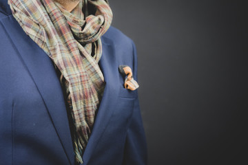 Fashionably dressed bearded Asian man in a scarf, jacket and pocket square.