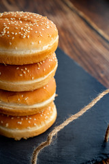 buns with sesame for burgers. black stone tray.