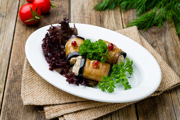 Eggplant rolls stuffed with nuts on wooden table