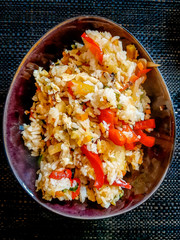 Un piatto di riso fritto con vegetali misti su un tavolo nero