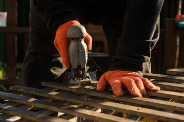Cutting wood with electric jigsaw.