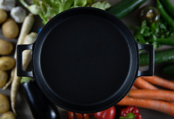 Cast iron frying pan with vegetables in background