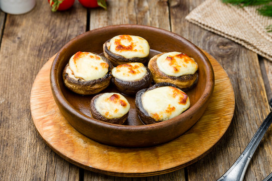 mushrooms baked with Suluguni cheese on wooden table