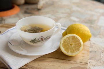 Obraz na płótnie Canvas cup of chamomile tea with lemon on a neutral background