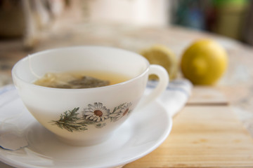 cup of chamomile tea with lemon on a neutral background