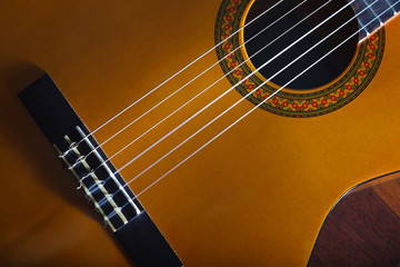 Yellow acoustic classic spanish guitar Popular music tune and song design banner. Close up, cropped and top view.