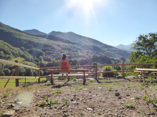 Chica sentada observando la montaña