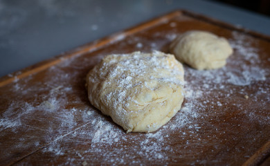 Fototapeta na wymiar Bread dough on floured board ,making bread rolls at home. hobby,