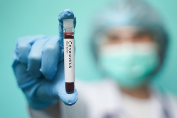 Asian woman doctor wearing protection Suit for Fighting Covid-19 or coronavirus. She holding test...
