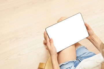 Obraz premium Home office. Young girl holding tablet with white screen. Mock up. Perfect for application. Bussiness women. Laptop gadget. Sitting child learn trendy technology