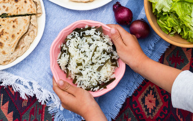 Asian steamed long rice with laminaria kelp seaweed in hands. Japanese and Chinese vegan food.