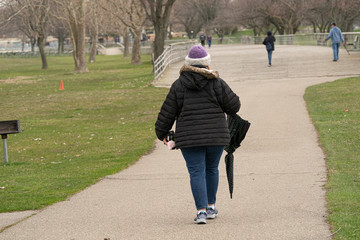 unknown woman carries her umbrella while taking a walk in the park