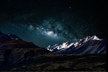 Backgrounds night sky with stars and milky way over the snow- capped mountains at south island new zealand