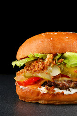 tasty burger with chicken on dark isolated background. Homemade hamburger or burger with fresh vegetables and cheese