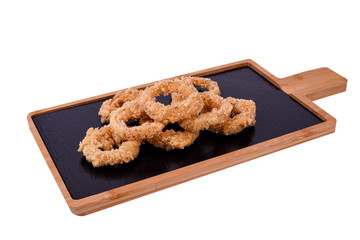 Deep fried calamari rings or onion on a wooden board isolated on a white background.