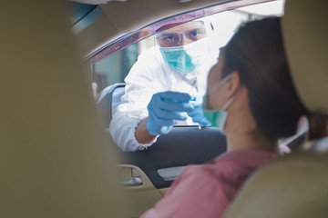 Medical worker in protective suit screening woman Driver to Sampling secretion to check for...