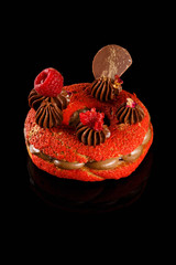 Naklejka premium Choux cream. Red velvet sweet bagel with Carmel cream filling and chocolate icing, raspberry fruit on top. Confectionery photography concept.