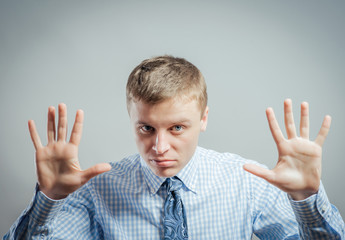 Afraid man in defense attitude gesturing stop with hands