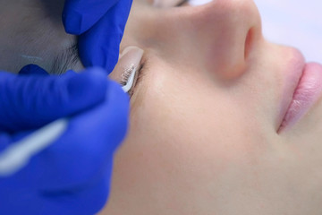 Cosmetologist bending lashes with needle into curlers, lift eyelashes laminaton procedure in beauty...